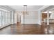Empty dining room with hardwood flooring, natural light, and wainscoting at 8900 River Trace Dr, Johns Creek, GA 30097