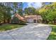 Brick home with a long drive way and mature tree canopy at 8900 River Trace Dr, Johns Creek, GA 30097