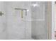 Close-up of marble tiled shower with glass door and gold hardware at 8900 River Trace Dr, Johns Creek, GA 30097