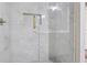 Shower stall featuring glass doors, and white marble tiling with gold accents at 8900 River Trace Dr, Johns Creek, GA 30097
