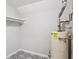 Utility room featuring patterned tile floors, white shelving, and a water heater at 8900 River Trace Dr, Johns Creek, GA 30097