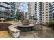 Outdoor fire pit with seating, offering a cozy gathering space amidst manicured grounds and residential buildings at 44 Peachtree Ne Pl # 1225, Atlanta, GA 30309
