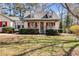 Inviting single-Gathering home showcasing a charming front porch, red shutters, and well-maintained landscaping at 21 Heather Ln, Villa Rica, GA 30180