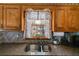 Double stainless steel kitchen sink under window with granite countertops and wood cabinets at 21 Heather Ln, Villa Rica, GA 30180