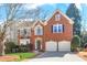 Charming two-story brick home featuring an attached two car garage and manicured landscaping at 420 Glenridge Close Ct, Atlanta, GA 30328