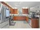 Well-lit kitchen features stainless steel appliances, tile floors, and wood cabinetry at 2316 Watson Fain Trl, Loganville, GA 30052