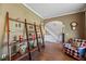 Inviting living room featuring hardwood floors, a stylish shelf, and arched doorways at 2316 Watson Fain Trl, Loganville, GA 30052