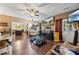 Spacious living room with hardwood floors, ceiling fan, and large-screen TV at 2316 Watson Fain Trl, Loganville, GA 30052