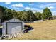 Backyard outbuilding with a roll-up door and adjacent storage area at 2316 Watson Fain Trl, Loganville, GA 30052