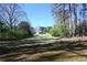 Large backyard space with mature trees and a glimpse of the house beyond, offering privacy and natural beauty at 1621 Oak Rd, Snellville, GA 30078