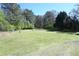Expansive backyard featuring lush greenery and mature trees, offering privacy and space for outdoor activities at 1621 Oak Rd, Snellville, GA 30078