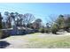 Charming exterior of the home with a well-maintained lawn, gravel driveway, and ample parking space at 1621 Oak Rd, Snellville, GA 30078