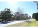Street view of the property featuring mature trees and a car parking area at 1621 Oak Rd, Snellville, GA 30078