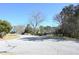 Street view of the property featuring mature trees and a car parking area at 1621 Oak Rd, Snellville, GA 30078