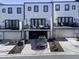 Modern townhome features a drive-under garage and balconies with dark trim windows and doors at 2533 Appleden Ne Pl # 22, Brookhaven, GA 30319