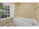 Relaxing bathroom with a large soaking tub next to a window offering view to an outside area at 52 Ivy Chase Ne, Atlanta, GA 30342