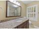 Bathroom featuring granite countertops, modern fixtures, and a framed mirror at 52 Ivy Chase Ne, Atlanta, GA 30342