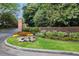 Community entrance with brick signage, colorful flowers, and mature trees at 52 Ivy Chase Ne, Atlanta, GA 30342
