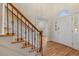 Bright foyer featuring hardwood floors, staircase with wrought iron spindles and arched transom window over the front door at 52 Ivy Chase Ne, Atlanta, GA 30342