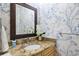Cozy powder room featuring a stylish vanity with granite countertop and blue floral wallpaper at 52 Ivy Chase Ne, Atlanta, GA 30342