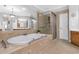 Bathroom featuring a jetted tub, walk-in shower, and neutral tile at 7524 Portbury Park Ln, Suwanee, GA 30024