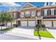 Charming brick townhome with a two-car garage and nicely landscaped front yard at 7524 Portbury Park Ln, Suwanee, GA 30024