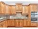 Gourmet kitchen featuring wood cabinets, granite countertops, and stainless steel appliances at 7524 Portbury Park Ln, Suwanee, GA 30024