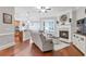Cozy living room with fireplace, hardwood floors, and view to the kitchen at 7524 Portbury Park Ln, Suwanee, GA 30024
