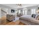 Large main bedroom with a sitting area, television, and access to a private balcony at 7524 Portbury Park Ln, Suwanee, GA 30024