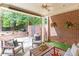 Covered patio with brick accents, outdoor seating, and a view of the landscaped backyard at 7524 Portbury Park Ln, Suwanee, GA 30024
