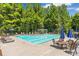 Community pool and lounge area, with blue umbrellas, ample seating, and a pergola in a treed environment at 7524 Portbury Park Ln, Suwanee, GA 30024