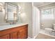 Bright bathroom featuring a stylish vanity, decorative window and tub with shower at 2447 Caladium Drive Northeast, Atlanta, GA 30345