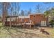 Expansive backyard featuring a large deck, brick house, mature trees, and lush greenery at 2447 Caladium Ne Dr, Atlanta, GA 30345