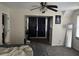 Another bedroom featuring a ceiling fan and view to another room with dark curtains and a full length mirror at 7977 Woods Ln, Jonesboro, GA 30236