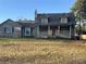 Charming two-story home featuring a cozy front porch and a well-maintained yard on a sunny day at 7977 Woods Ln, Jonesboro, GA 30236