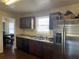Efficient kitchen featuring stainless steel refrigerator, dark cabinets, and a view into the dining area at 7977 Woods Ln, Jonesboro, GA 30236