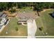 Aerial view of a two-story home with a large backyard, a long driveway, and surrounded by mature trees at 2106 Sycamore Ln, Loganville, GA 30052