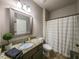 Bathroom showcases a granite countertop, framed mirror, and a shower with patterned curtain at 2106 Sycamore Ln, Loganville, GA 30052
