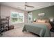 Stylish bedroom showcasing a muted green accent wall, plush carpeting, and a modern ceiling fan at 2106 Sycamore Ln, Loganville, GA 30052