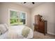 Bedroom features a large window with a view and a classic wooden dresser with candle decor at 2106 Sycamore Ln, Loganville, GA 30052