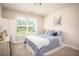 Cozy bedroom featuring soft blue bedding, natural light from the window, and plush carpeting at 2106 Sycamore Ln, Loganville, GA 30052