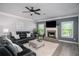 Cozy living room with brick fireplace, dark leather furniture, and a ceiling fan at 2106 Sycamore Ln, Loganville, GA 30052