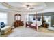 Spacious main bedroom featuring a four-poster bed, sitting area, and elegant decor at 2106 Sycamore Ln, Loganville, GA 30052