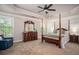 Main bedroom with tray ceiling, four poster bed, dresser and view from the windows at 2106 Sycamore Ln, Loganville, GA 30052