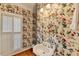 This bathroom features floral wallpaper, a pedestal sink, and bright lighting at 235 Haydens Walk Ct, Johns Creek, GA 30022