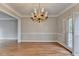 Formal dining room featuring a decorative chandelier, detailed trim, and hardwood floors at 235 Haydens Walk Ct, Johns Creek, GA 30022