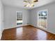 Bright bedroom with hardwood floors, ceiling fan, and two windows overlooking the exterior at 8005 Bamby Ln, Jonesboro, GA 30236