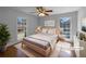Serene bedroom with natural light from two windows and a stylish wood bed frame complemented by hardwood floors and minimalist decor at 8005 Bamby Ln, Jonesboro, GA 30236