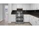 Bright kitchen featuring stainless steel oven with a gas stovetop, white cabinets, and dark countertops at 8005 Bamby Ln, Jonesboro, GA 30236