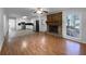 Open-concept living area featuring a stone fireplace, hardwood floors, and access to a kitchen, creating a cozy and inviting atmosphere at 8005 Bamby Ln, Jonesboro, GA 30236